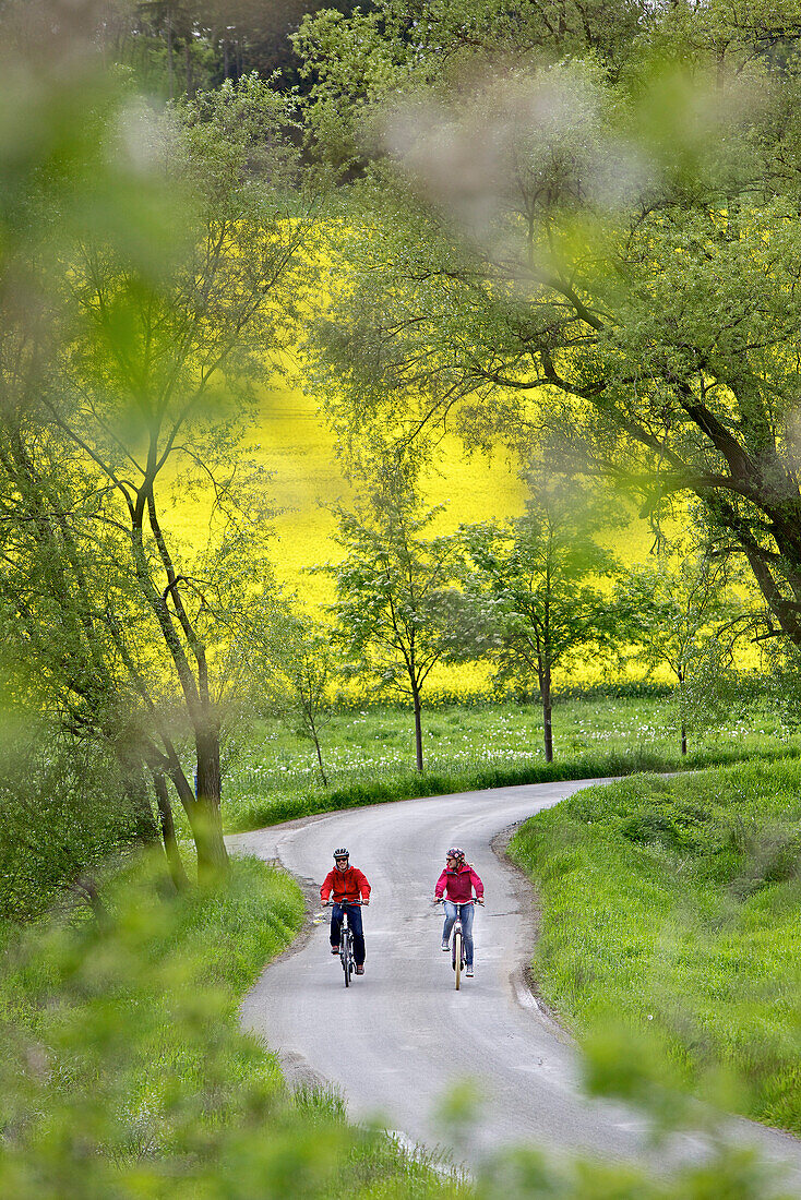 Two cyclists riding electric bicycles, Tanna, Thuringia, Germany