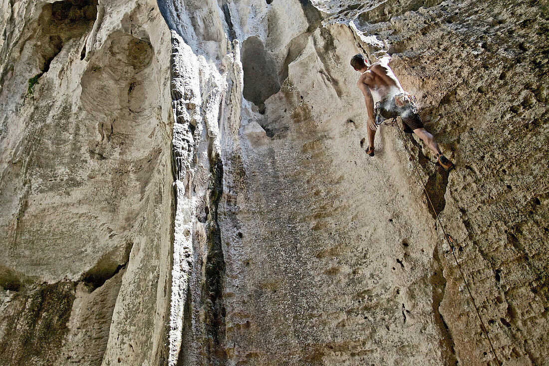 Junger Mann klettert eine Felswand hinauf, Finale Ligure, Savona, Italien