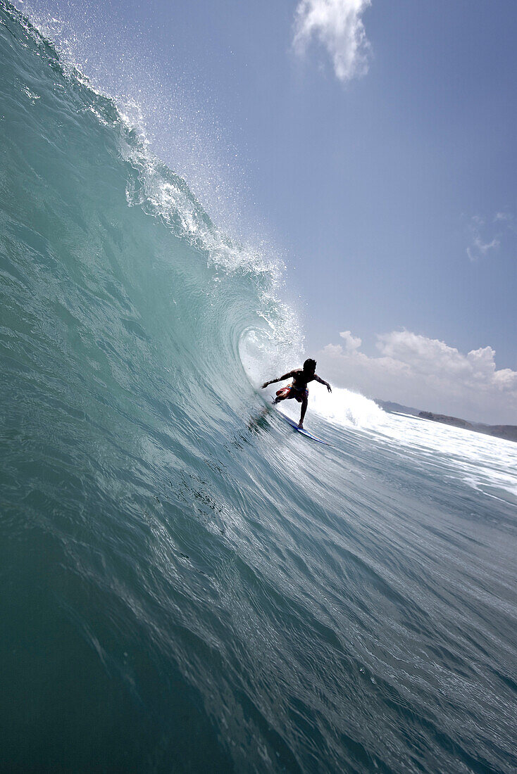 Surfer reitet eine Welle, Mataram, Lombok, Indonesien