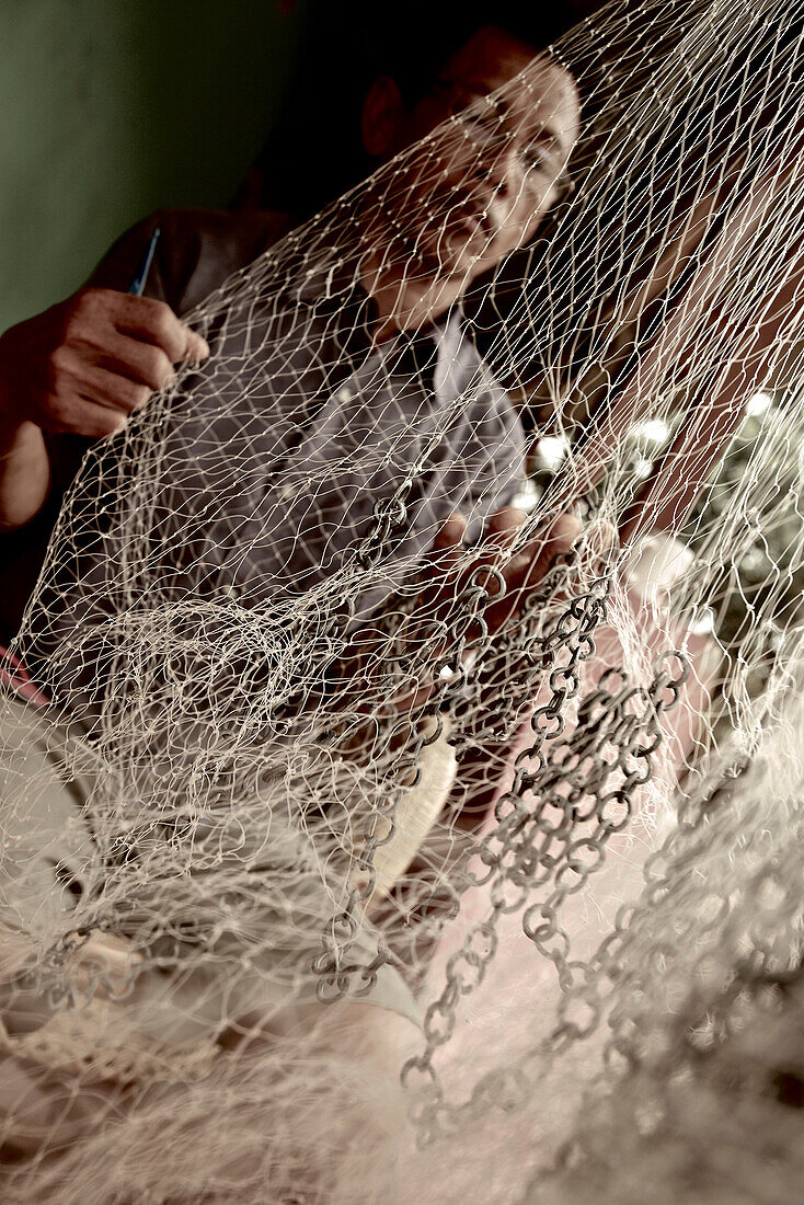 Fisherman reparing fishnet, Mataram, Lombok, Indonesia