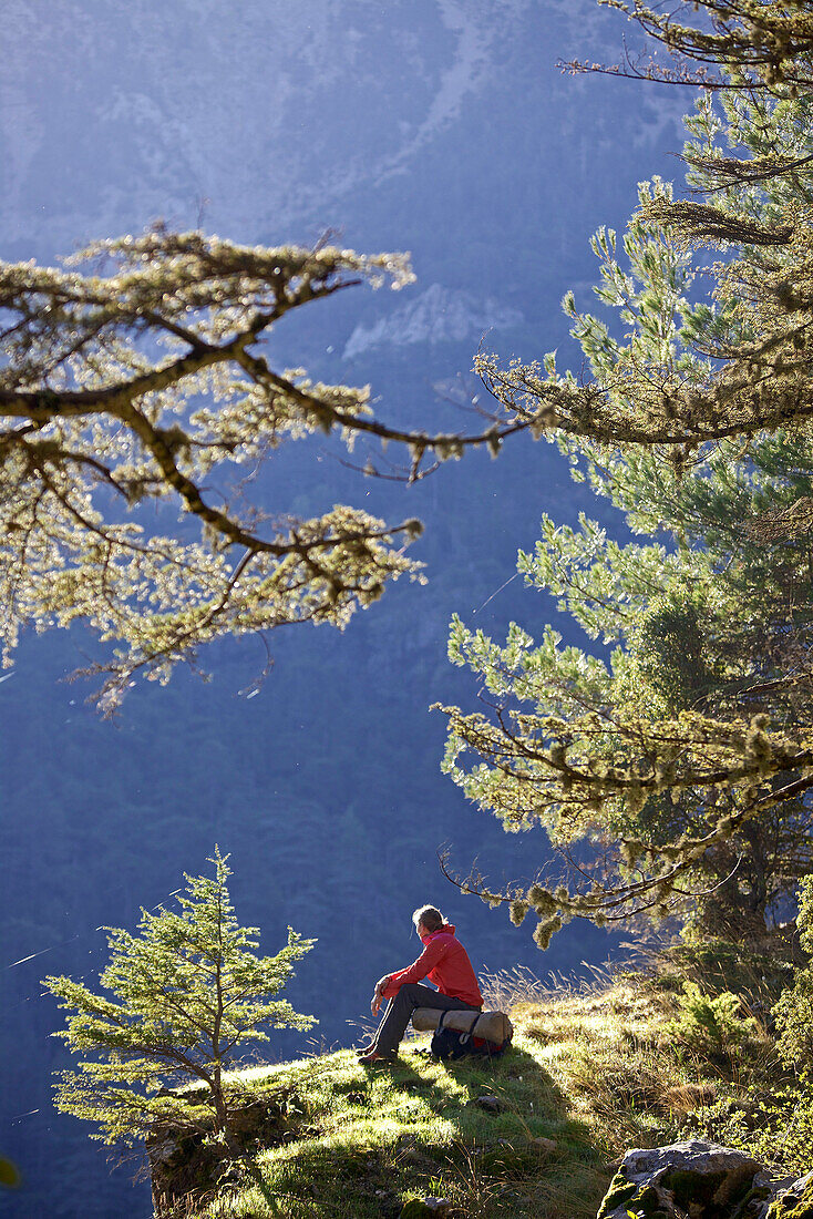 Woman resting on a rock in a forest, long-distance footpath Lycian Way, Antalya, Turkey