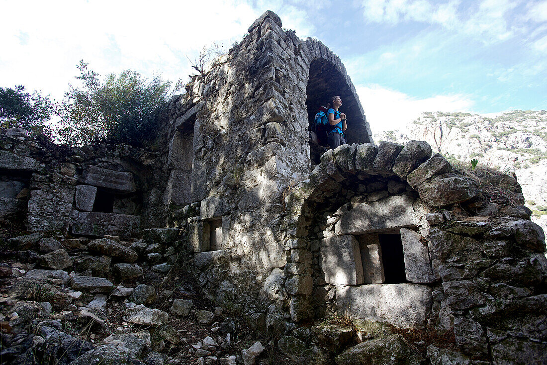Woman visiting ancient ruins beside long-distance footpath Lycian Way, Antalya, Turkey