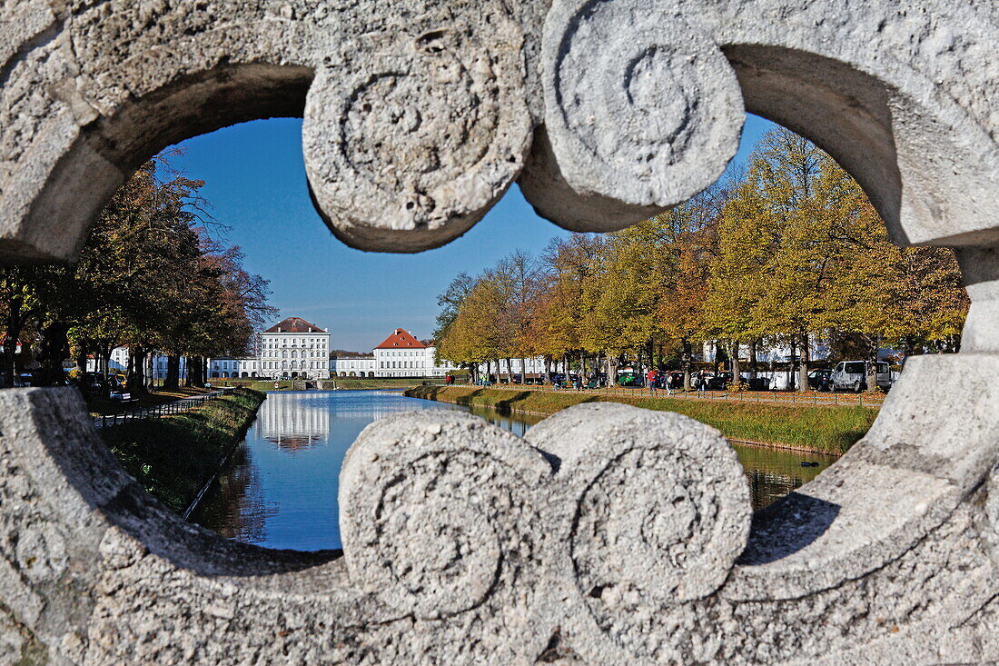 View through the bridge railing of Ludwig-Ferdinand-bridge over Schlosskanal, with Nymphenburg palace in the background, Munich, Upper Bavaria, Bavaria, Germany