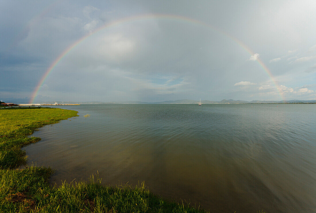 Rainbow seen from the lake shore of lake Castiglione del Lago, Lago Trasimeno, province of Perugia, Umbria, Italy, Europe