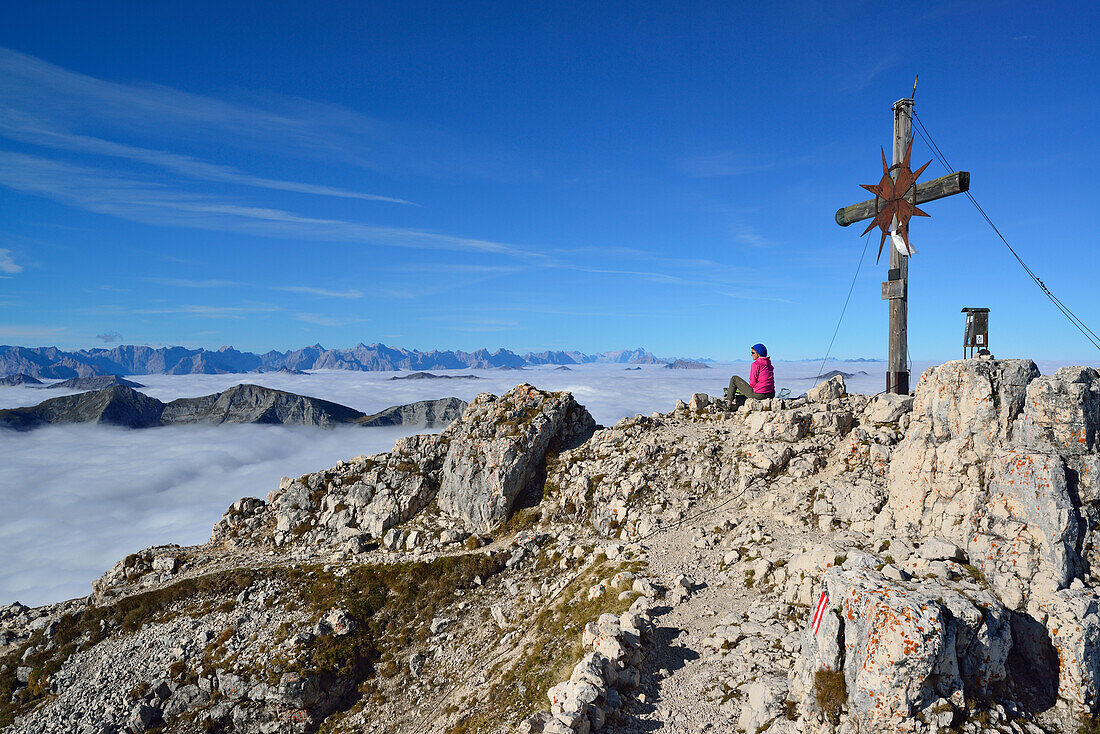 Frau sitzt am Gipfel des Guffert, Blick auf Unnütz, Karwendel und Wetterstein mit Zugspitze, Brandenberger Alpen (Rofan), Tirol, Österreich