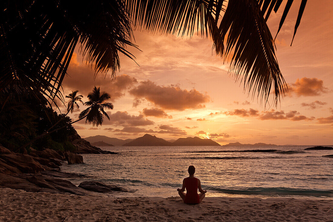 J oga bei Sonnenuntergang, Anse Severe beach, La Digue, Indischer Ozean, Seychellen, Indischer Ozean