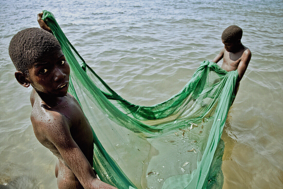 Two boys fishing with a fishing net, Lake Malawi, Malawi, Africa
