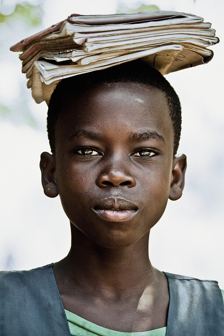 Ein Schulmädchen mit Schulheften auf dem Haupt, Malawi, Afrika