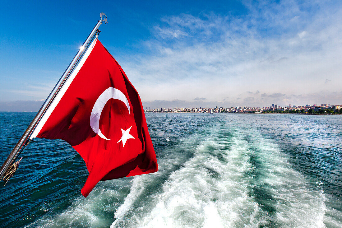 Turkish flag from a boat with the city behind, Bosphorus, Istanbul, Turkey
