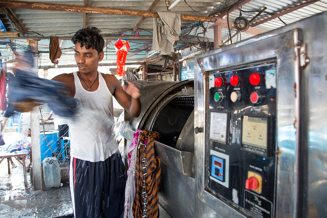 Mann wäscht Wäsche in der Freiluft-Wäscherei Mahalaxmi Dhobi Ghat, Mumbai, Maharashtra, Indien