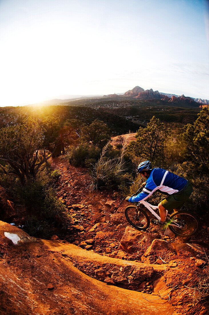 A middle age man rides his mountain bike through the red rock country around Sedona, Az at sunset Sedona, AZ, USA