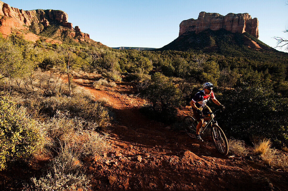 A middle age man rides his mountain bike through the red rock country of Sedona, AZ Sedona, AZ, USA