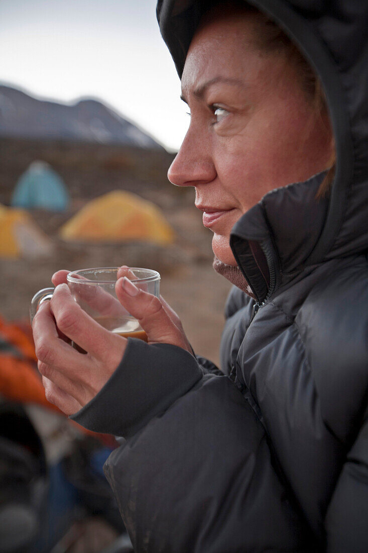 A woman drinks tea at camp on Mount Kilimanjaro, Tanzania Tanzania