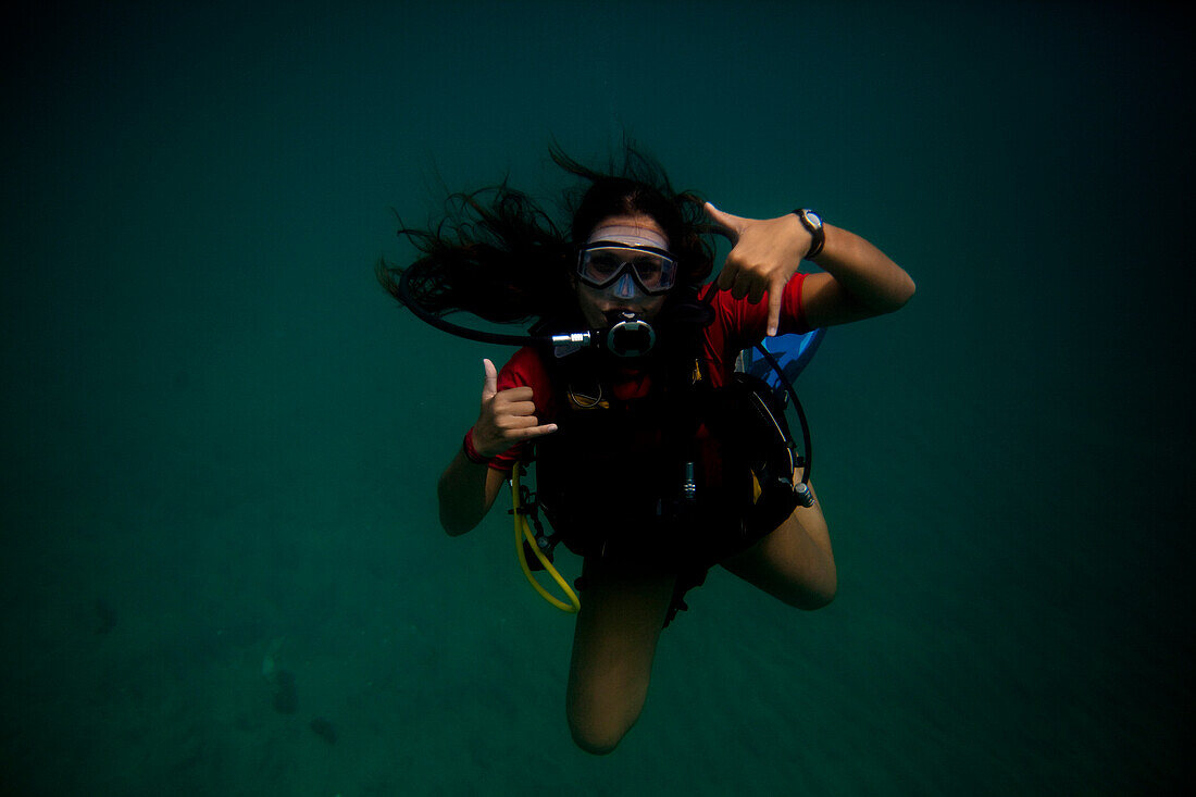 A young Hispanic woman scuba dives in the Caribbean Sea Sandy Point Town, St Kitts