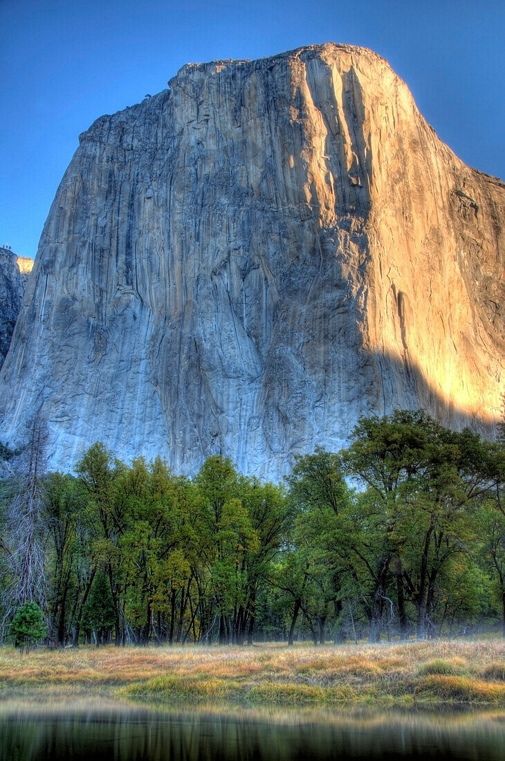 Looking over the Merced River, early morning sunlight hits El Capitan in Yosemite National Park, CA Yosemite National Park, California, USA