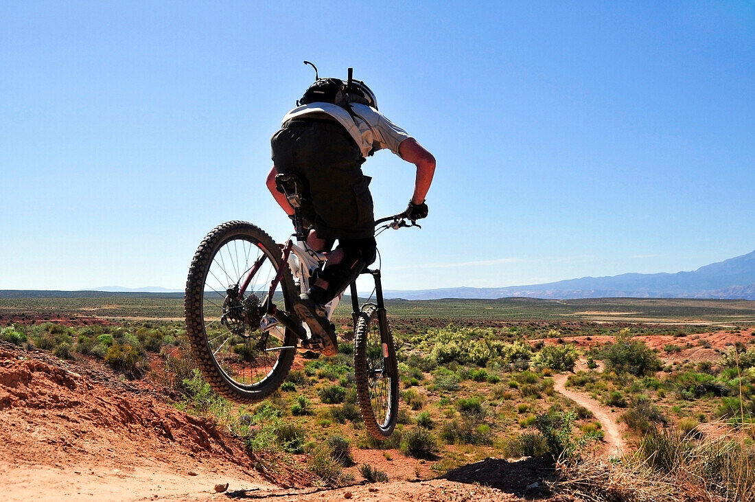 A mountain biker catches some air on the JEM trail in southern Utah Virgin, Utah, USA