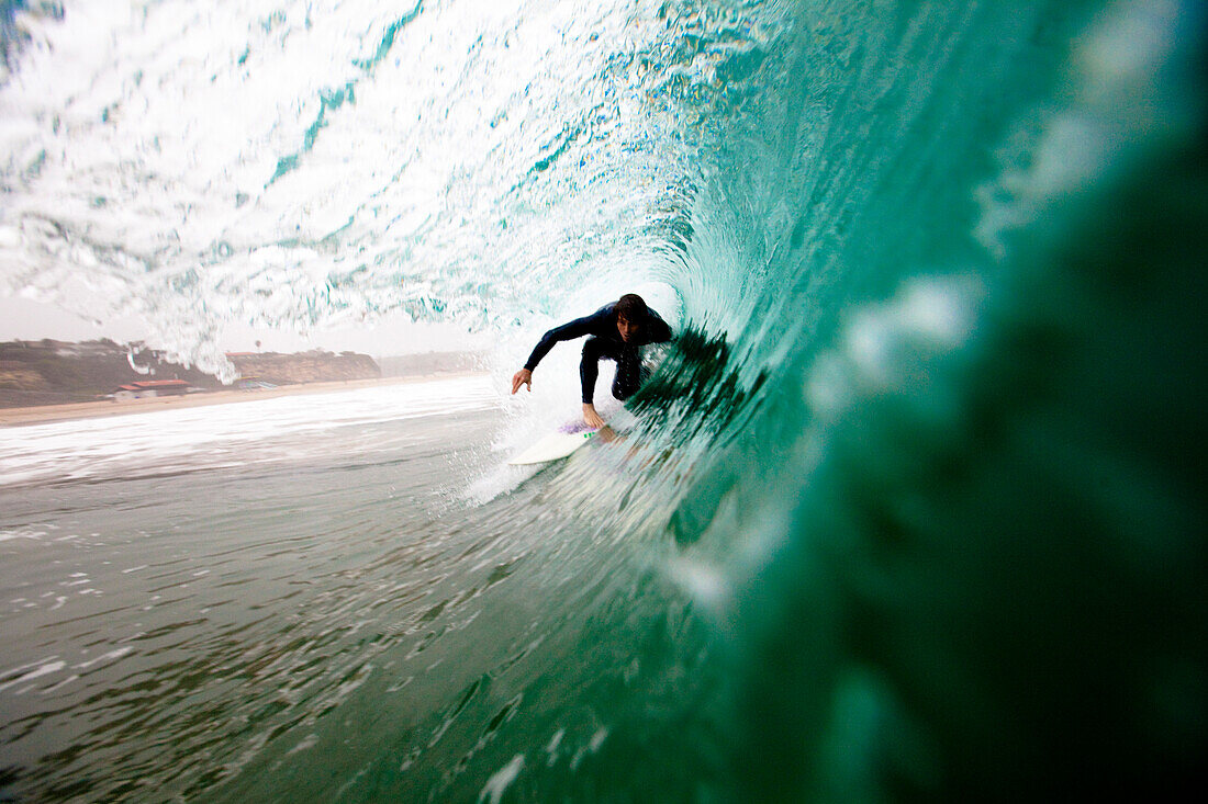 A male surfer pulls into a barrel while surfing at Zuma beach in Malibu, California Malibu, California, United States of America