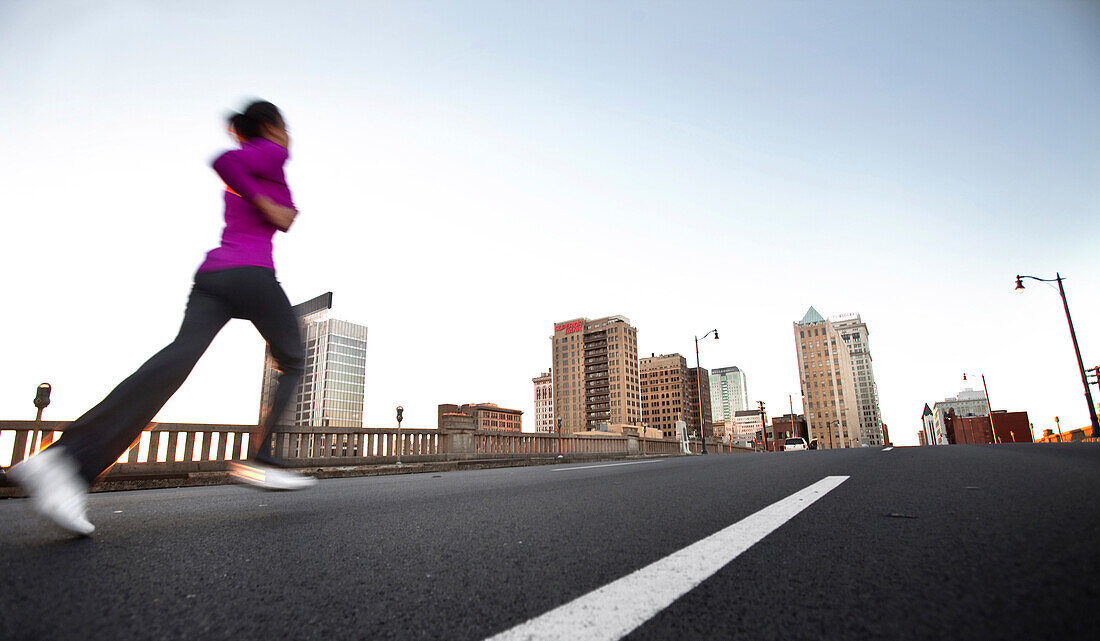 A teenage girl runs on the street away from the camera towards downtown Birmingham, Alabama. (motion blur), Birmingham, Alabama, United States