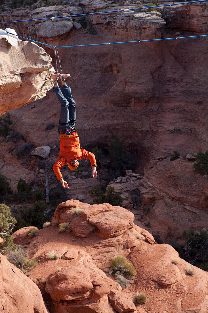 A highliner takes a fall with a rope tied to both feet, Moab Utah Moab, Utah, United States
