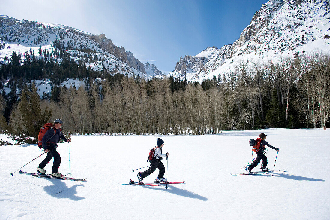 A father and his two sons skinning through the backcountry of California Sierra, CA, USA