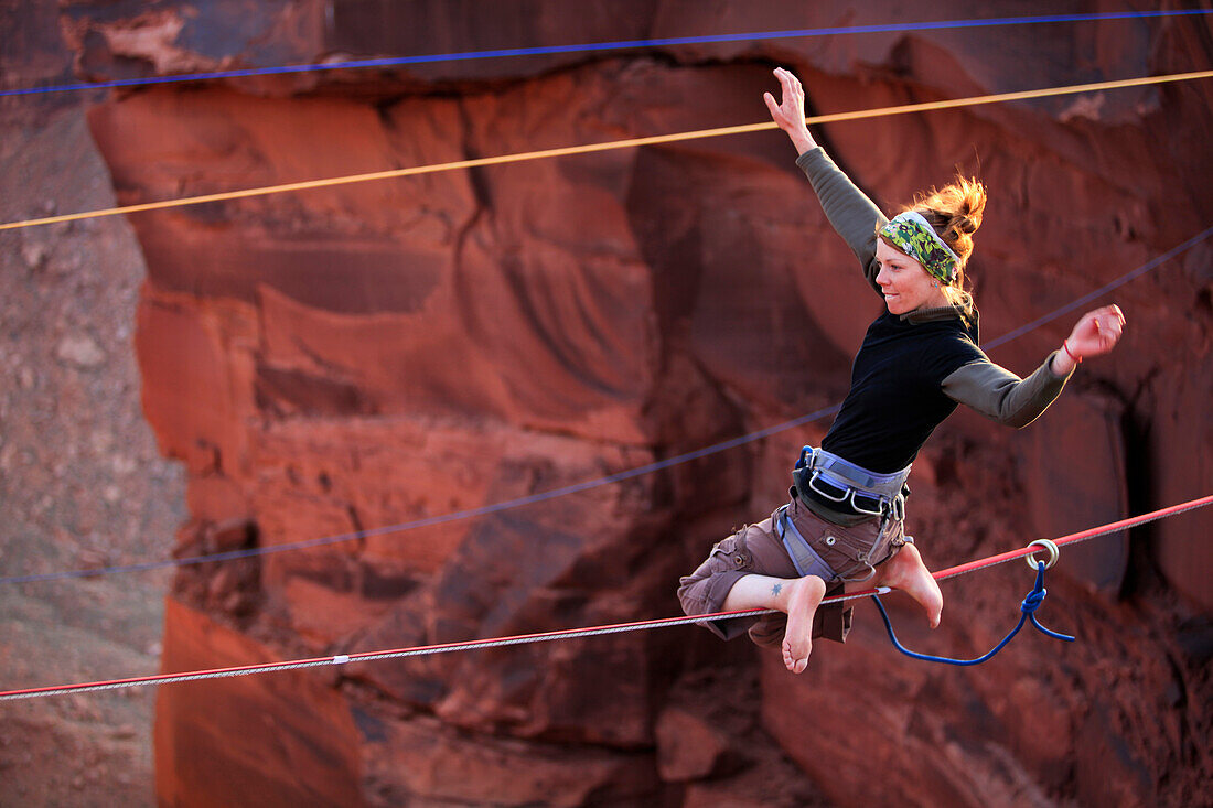 A female highliner poses on a highline at the Fruit Bowl in Moab, Utah, USA Moab, Utah, United States