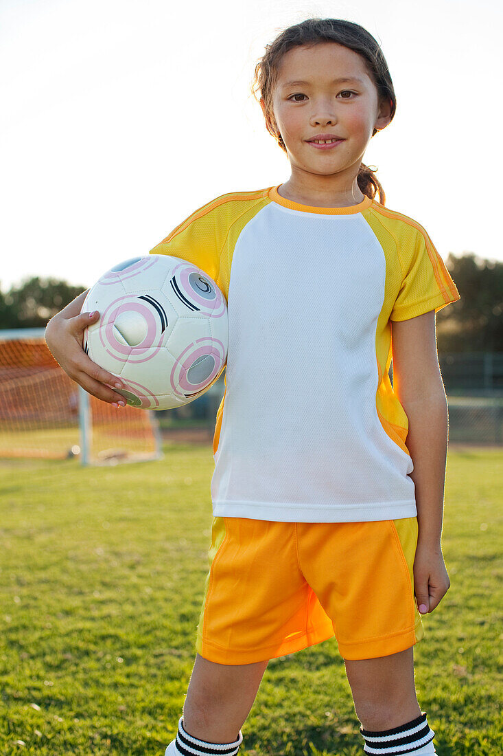 A young girl posing with her soccer ball on a soccer field in Los Angeles, California Los Angeles, California, USA