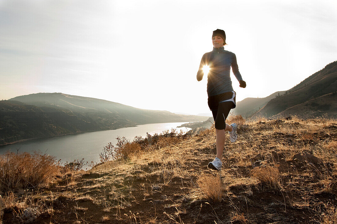 An athletic woman jogging in the Columbia Gorge, Oregon Hood River, Oregon, USA