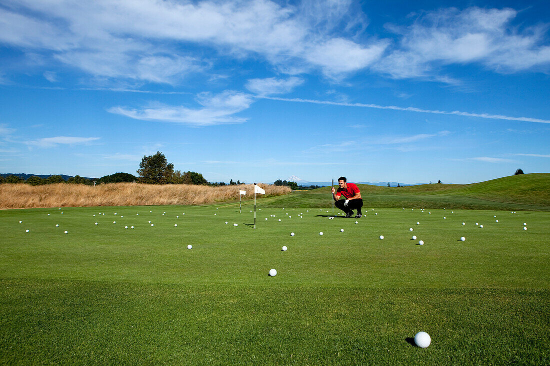 Man lining up a putt while golfing Portland, Oregon, USA
