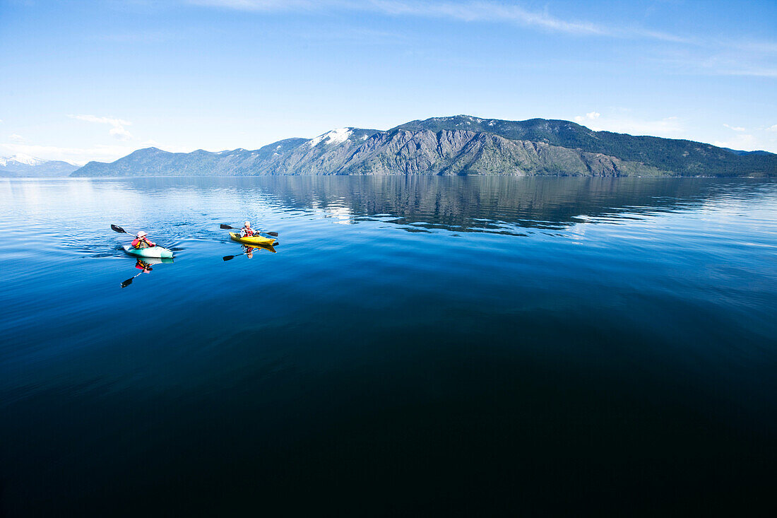 An happy adventurous retired couple kayaking on a huge calm lake in Idaho Sandpoint, Idaho, USA