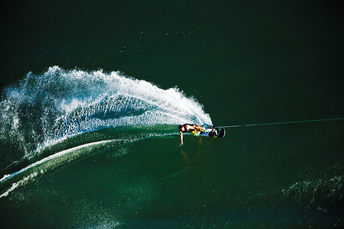 A athletic wakeboarder carves and slashes on a calm day in Idaho. Shot from above Sandpoint, Idaho, USA