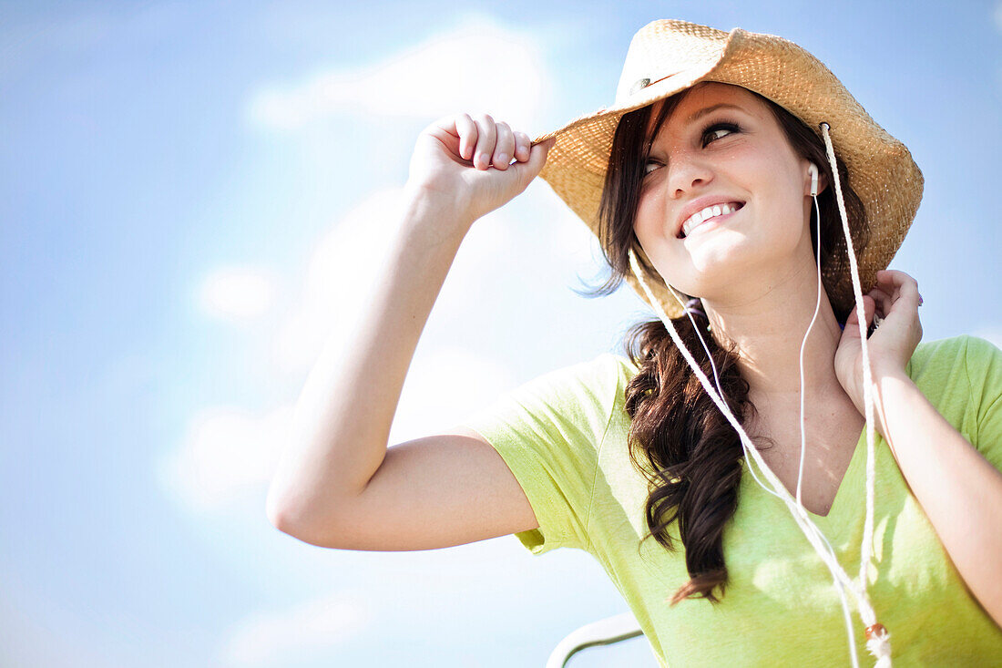 A young woman looks off while smiling listening to music Gadsden, Alabama, United States