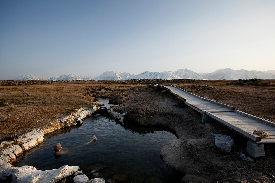 A man enjoys a hot spring near the mountains Bishop, California, United States