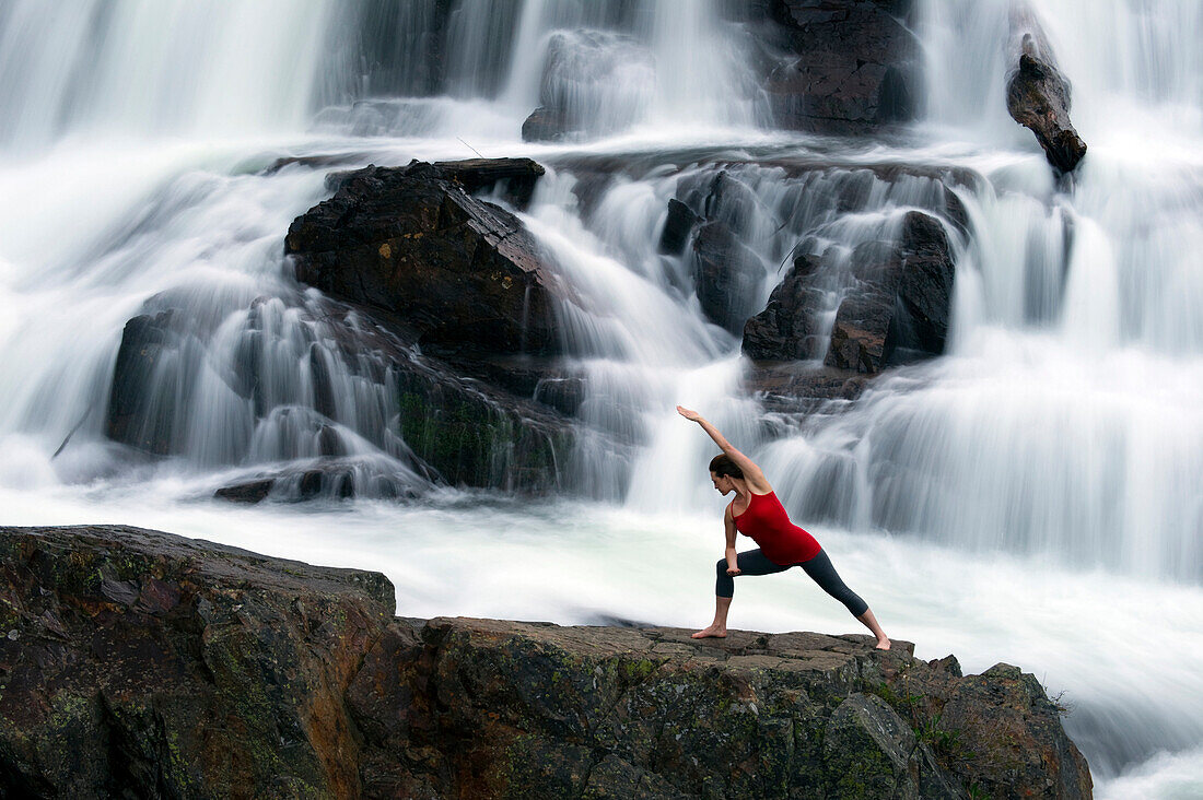 A woman performs yoga in front of a large waterfall in Lake Tahoe, California Lake Tahoe, California, USA