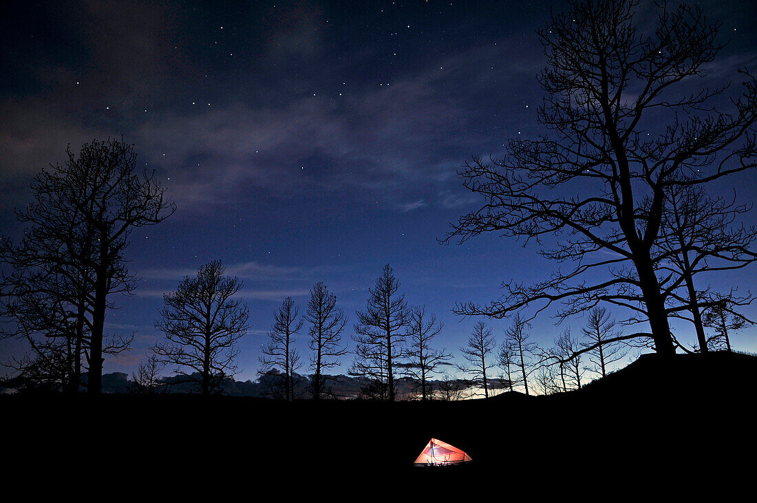 A tent illuminates the starry night sky at Sugarite Canyon State Park near Raton Pass on the New Mexico and Colorado borders