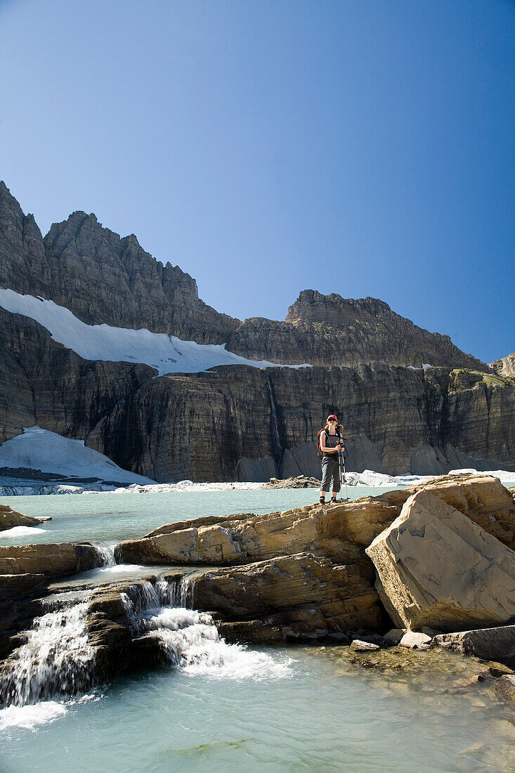 A woman in her early thirties hikes along the Grinnell Glacier trail in Glacier National Park, Montana Glacier National Park, Montana, United States of America