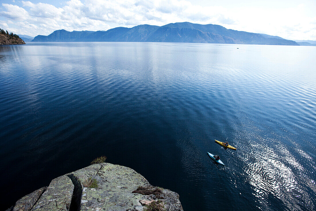 A young adult couple kayaking on a sunny day on a lake in Idaho., Sandpoint, Idaho, USA