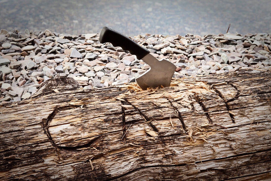 A hatchet burried into a log that reads camp next to a lake in Idaho., Sandpoint, Idaho, USA