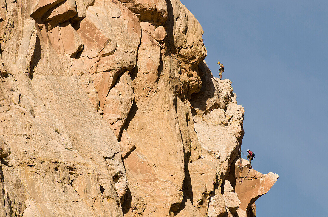 Two men rock climbing a sandstone prow in the San Rafael Swell, Green River, Utah., Green River, Utah, usa