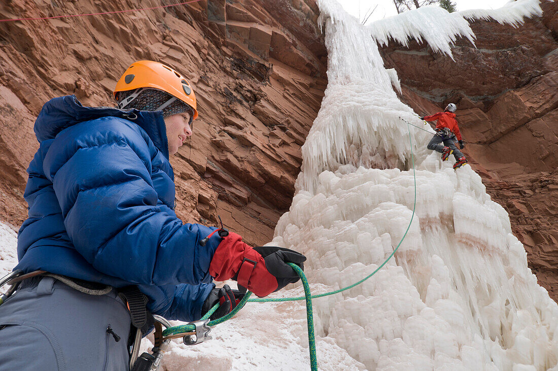 Two men ice climbing up an ice pillar, San Juan National Forest, Durango, Colorado., Durango, Colorado, usa