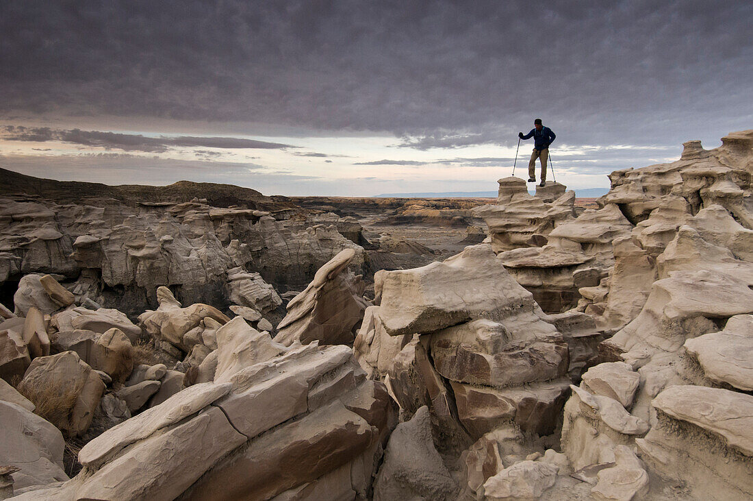 A man hiking through the complex sandstone rock formations at Bisti Badlands, Farmington, New Mexico., Farmington, New Mexico, usa