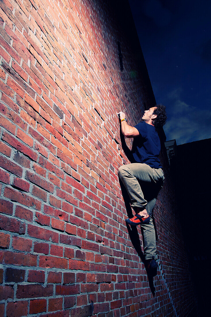 A climber scales an old brick wall in Groningen, the Netherlands., Groningen, Groningen, The Netherlands