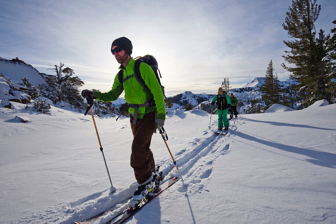 Skiers and snowboarders skin through powder snow on Carson Pass in the Sierra Nevada mountains near Lake Tahoe, CA., Carson Pass, California, USA
