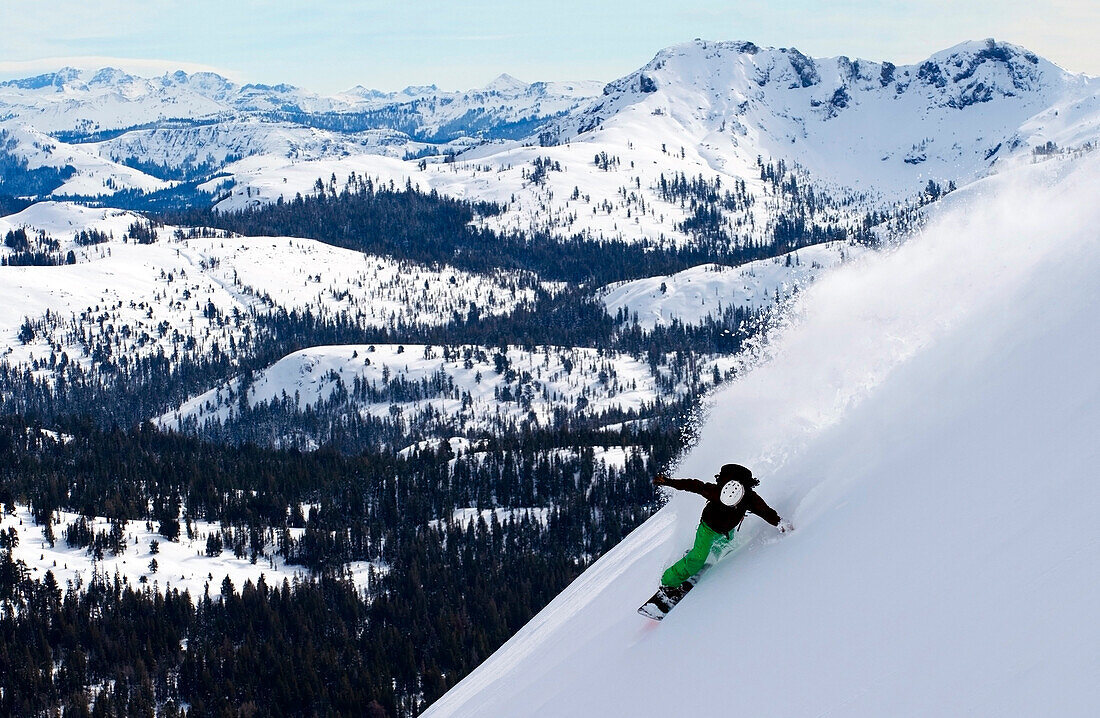 A snowboarder rips a huge turn in deep powder on Red Lake Peak off of Carson Pass near Lake Tahoe, CA., Carson Pass, California, USA