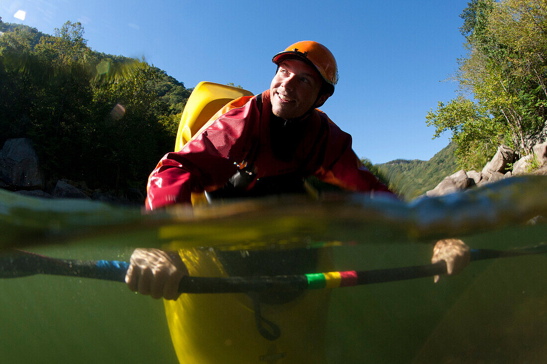 Split level view of one man smiling and doing a bow stall in his kayak., Fayetteville, WV, USA