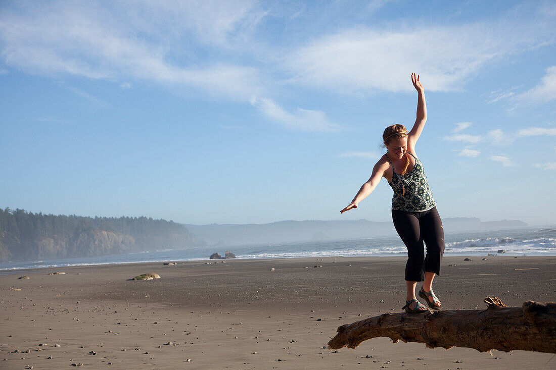 Young woman balancing on log near Third Beach in Olympic National Park, WA., Moab, Utah, USA