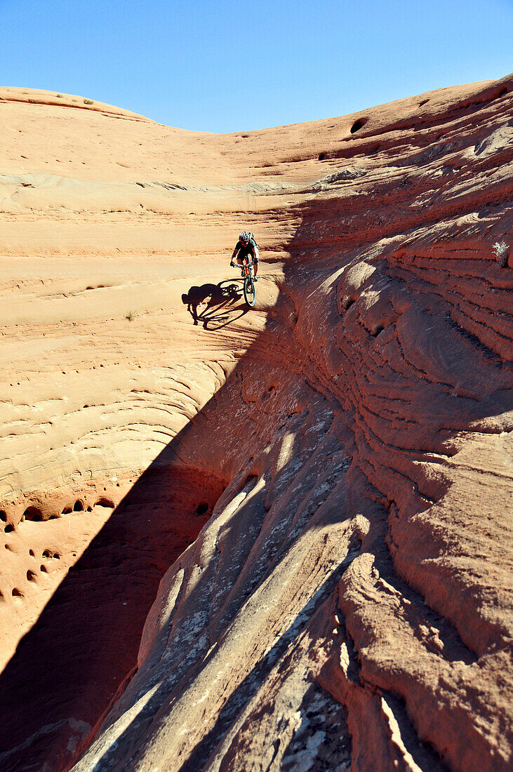A mountain biker descends an extremely steep line on sandstone near Moab, UT., Moab, Utah, USA