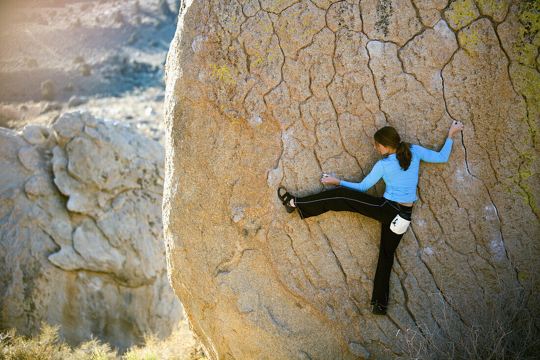 Woman bouldering on an overhang, Buttermilk Boulders, California, United States