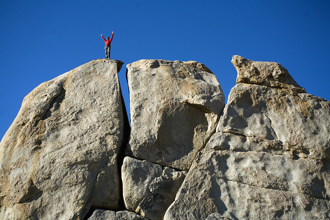 Male climber on top of rock, Bishop, California, United States