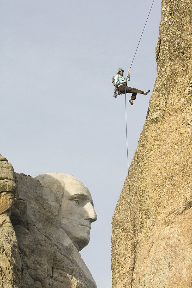 Woman rappelling rock face Hill City, South Dakota, United States