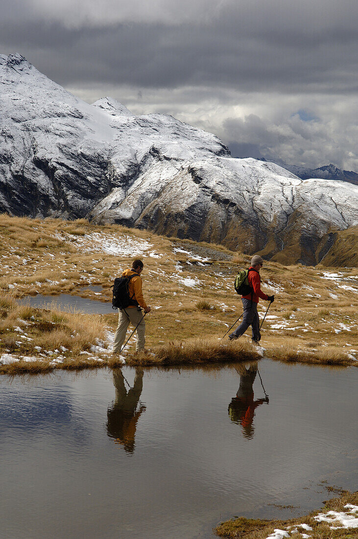 Mountain hikers near reflection pool South Island, New Zealand